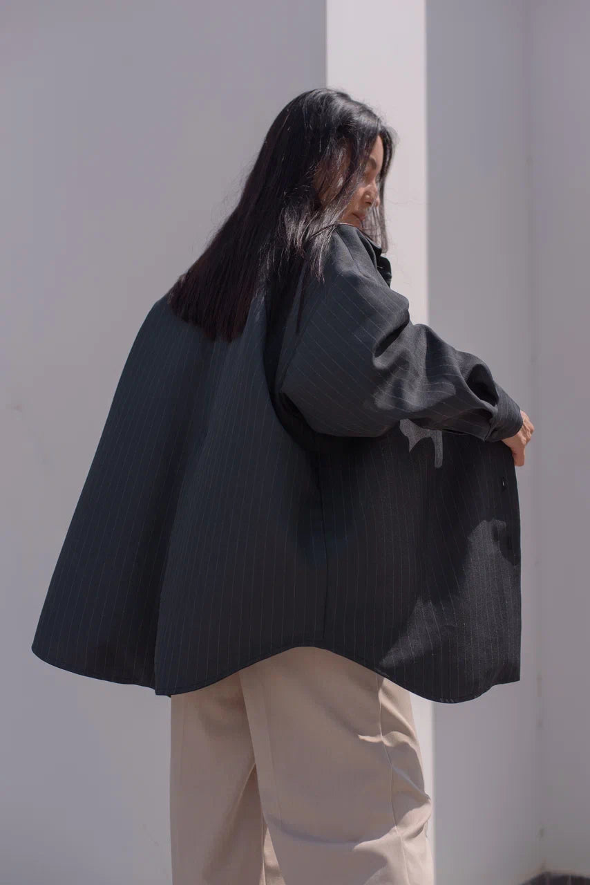 Side view of an oversized pinstripe blazer shirt.